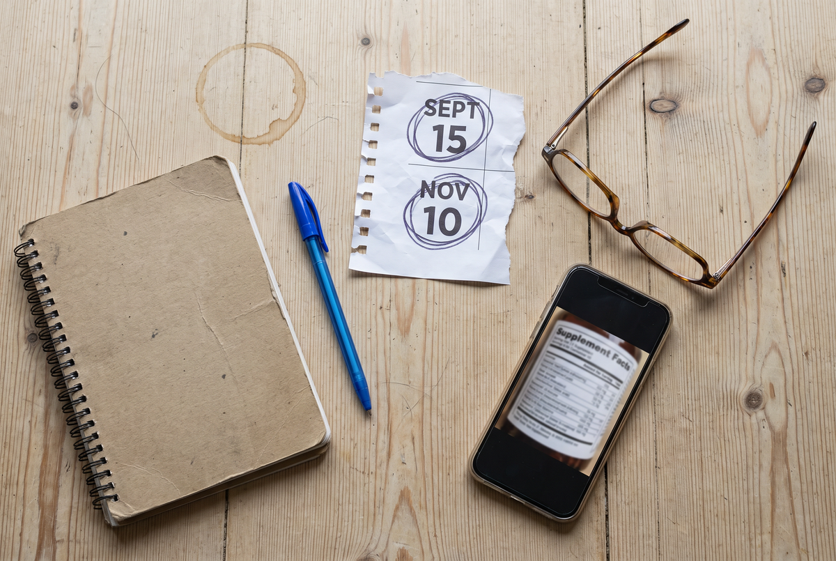 Notebook, biro, calendar page, reading glasses and a photo of the label.