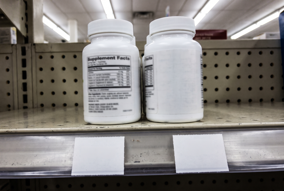 Two plain bottles on a shelf, backs to the camera.