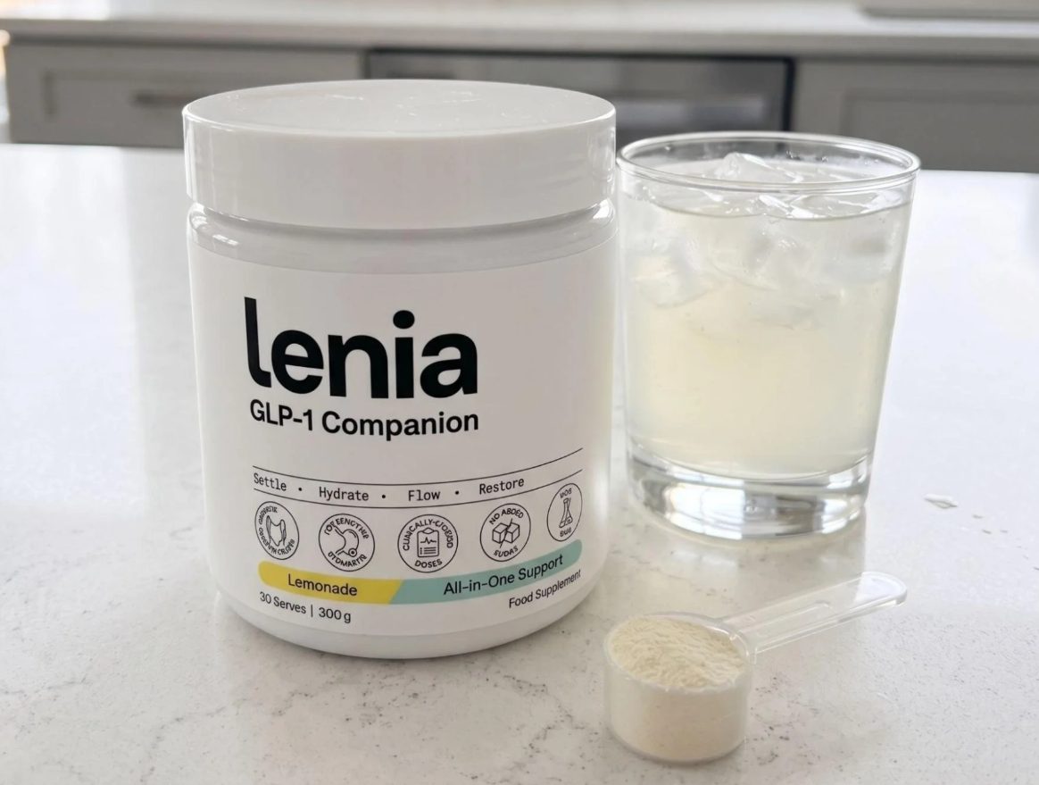 The Lenia GLP-1 Companion tub on a counter beside a glass of lemonade and a filled scoop.