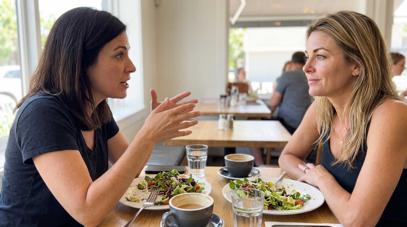 Two friends having lunch together at a cafe table